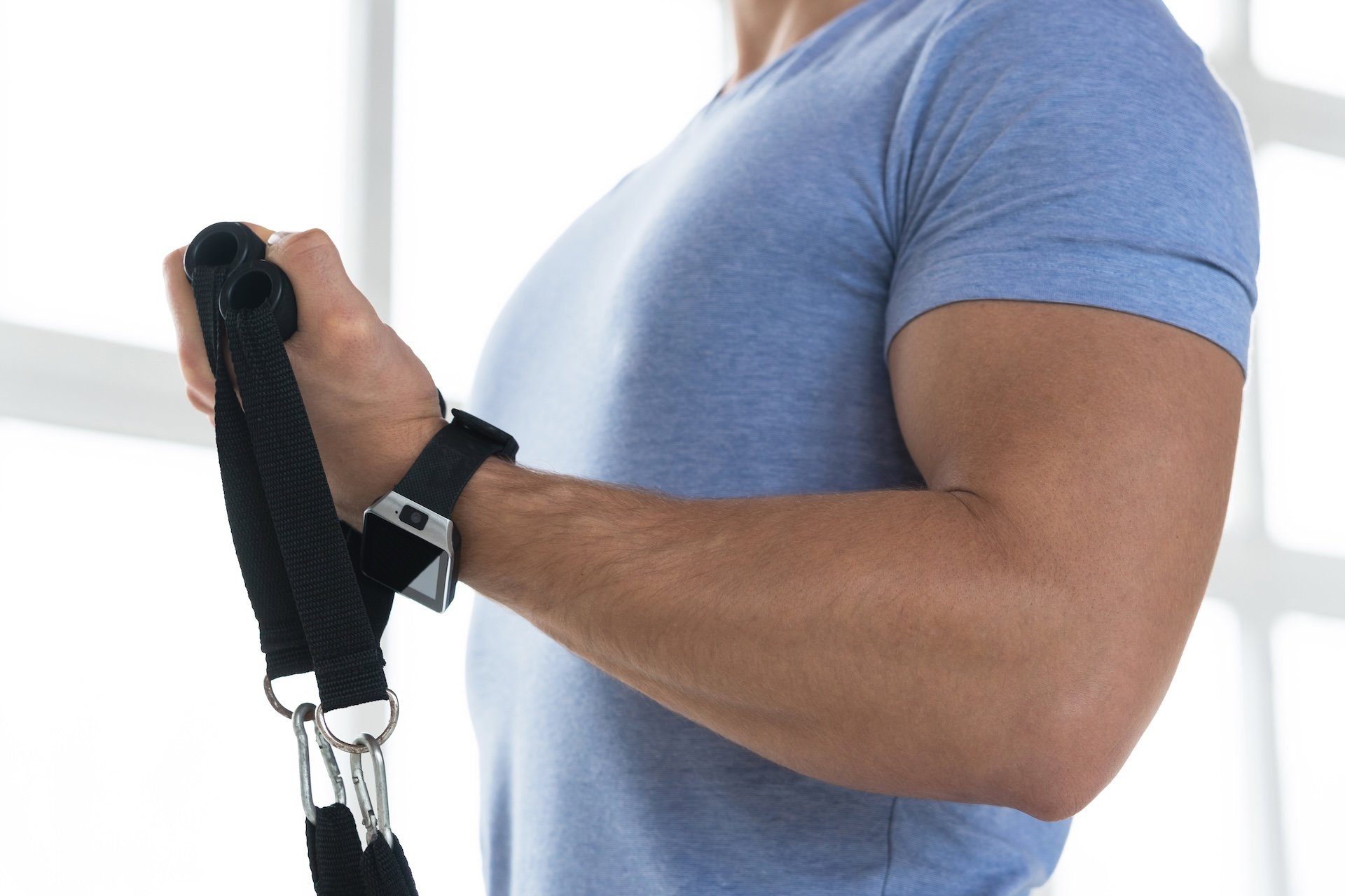 Man doing a resistance band biceps curl at the gym